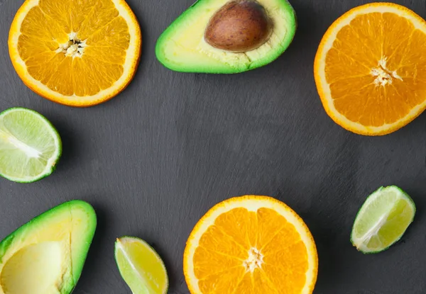 avokado, portakal ve limon taş tahta üzerinde