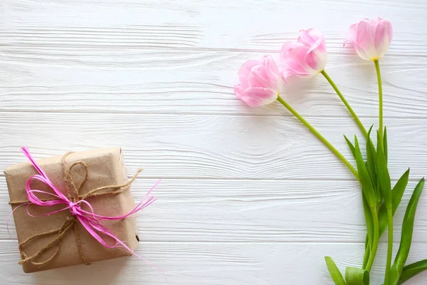 Ahşap beyaz arka plan, mevcut ve Pembe Lale. Mart 8, Mothe