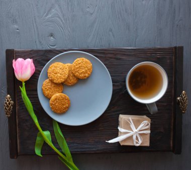 Anneler günü, kadının gün. Lale, hediyeler, çay ve tatlılar ahşap arka plan üzerinde