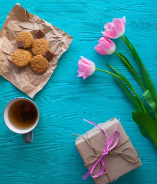 Anneler günü, kadının gün. Lale, hediyeler, çay ve tatlılar ahşap arka plan üzerinde