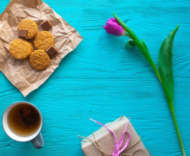 Anneler günü, kadının gün. Lale, hediyeler, çay ve tatlılar ahşap arka plan üzerinde