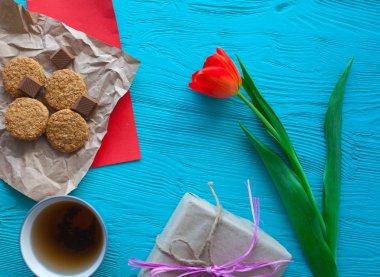 Anneler günü, kadının gün. Lale, hediyeler, çay ve tatlılar ahşap arka plan üzerinde