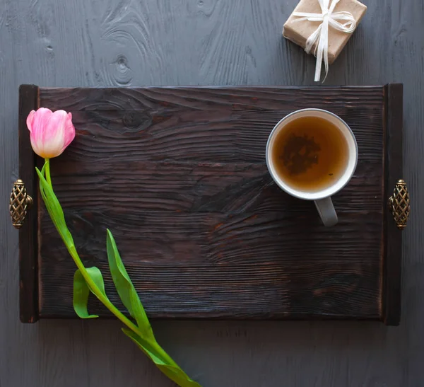 День матери, женский день. тюльпаны, подарки, чай и сладости на деревянном фоне Стоковое Фото