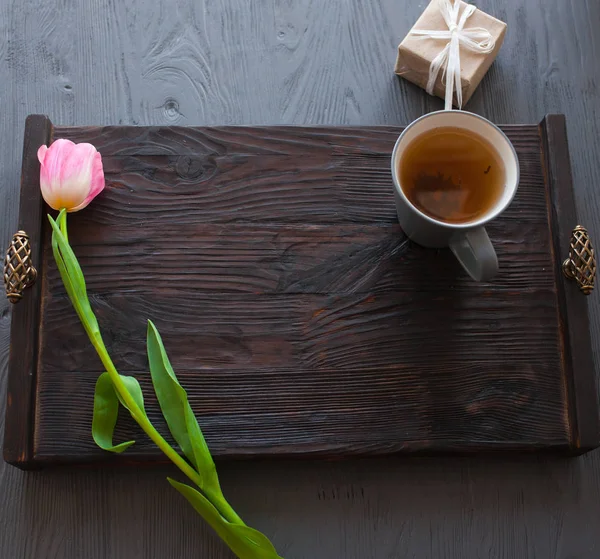 День матери, женский день. тюльпаны, подарки, чай и сладости на деревянном фоне Лицензионные Стоковые Изображения