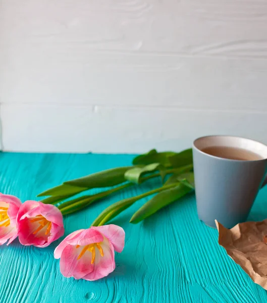 День матери, женский день. тюльпаны, подарки, чай и сладости на деревянном фоне Стоковая Картинка