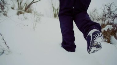 ağır çekim. Erkekler katiyen backpackfoot ayak yükseltiler kar kış manzara içinde yürümek