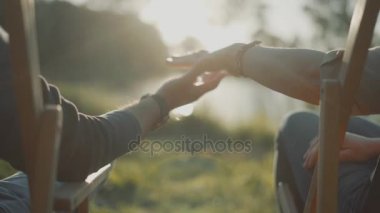 İki aşık adam ve kadın katılmadan eller gün batımı göl arka plan üzerinde kapat