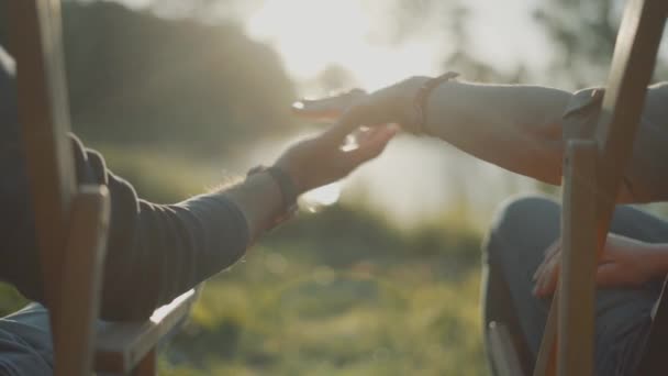 Gros plan de deux amants Un homme et une femme se joignent à la main sur le fond du lac Sunset 