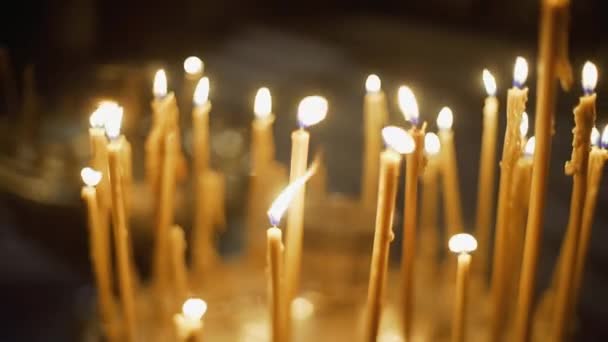 Uitzicht op de kerk veel kaarsen branden in de tempel — Stockvideo