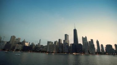 Bir tekne Michigan Gölü'nden Gölü whit günbatımı Chicago şehir şehir gökdelenlerin görünümünde yansıyan