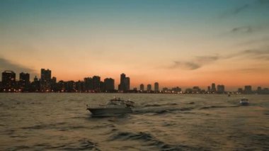 akşam şehrin arka plan üzerinde tekne yelken