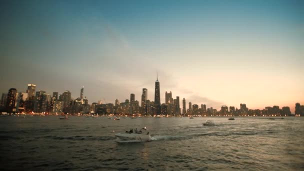 Лодка плывет на фоне вечернего города, широкая — стоковое видео