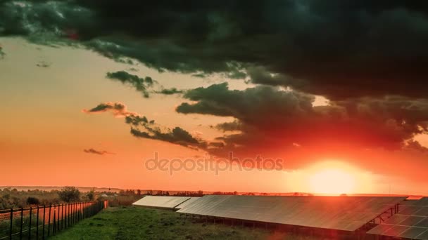 Time Lapse, Rich yellow, orange, red colors light up solar panel at sunset. move cloud and sun — Stock Video