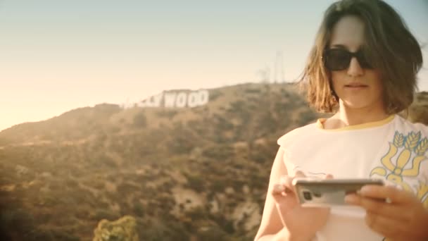 Tourist taking photograph of sunset in hollywood sign — Stock Video