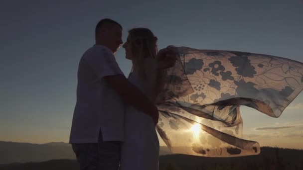 Slowmotion Amazing Sunset e uma jovem mulher segurando um pano transparente, acenando em um vento — Vídeo de Stock
