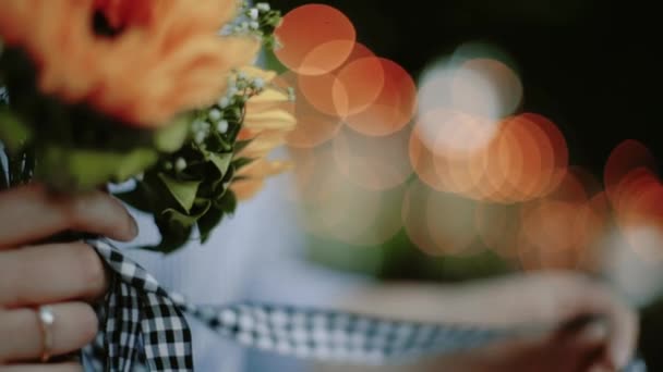 Bir buket çiçek el, inanılmaz bokeh tutan kadın — Stok video