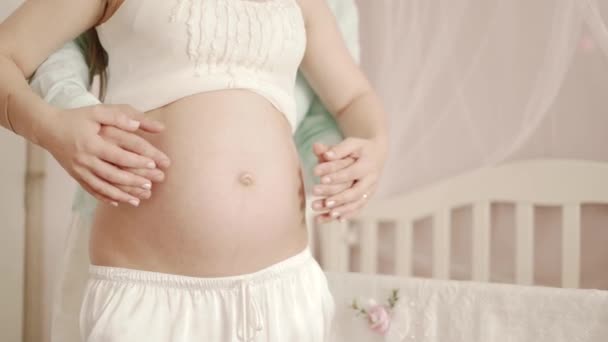 A pregnant woman and her husband in home hugging belly — Stock Video