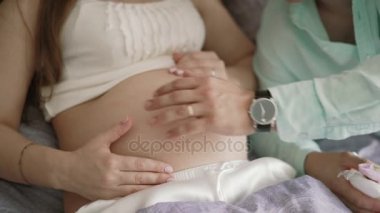 Hamile bir kadın ve kocası evde yatakta ve ha sarılma göbek