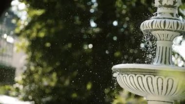 Su su çeşmesi ağır çekimde sıçramasına bırakır. Yakın çekim