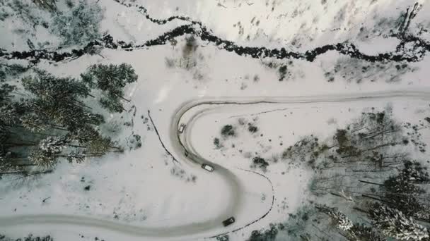 Luchtfoto van twee auto glijden op een ijzige weg in winter forest — Stockvideo