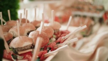 Bir ltable bir sürü hamburger ve tatil Ziyafet gıda ile plakalar.