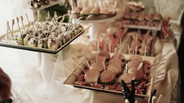 Стіл з великою кількістю тарілок з їжею на святковому бенкеті . — стокове відео