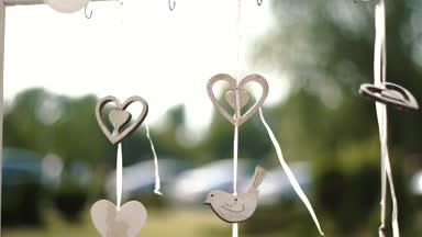 Güzel açık havada tatil dekorasyon. Ahşap kalpleri ve yavaş rüzgarla hareket kuşlar.