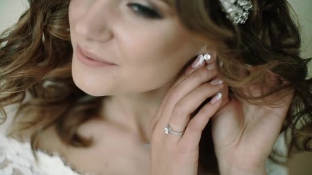 Bride corrige la boucle d'oreille en la touchant avec ses doigts et en descendant — Video