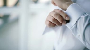 Ağır çekim. Damat giyer şık kol düğmeleri yakın çekim