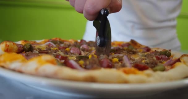 Chef tranchant une pizza pepperoni en plusieurs tranches avec un coupe-pizza. Gros plan au ralenti. Ver 5 — Video