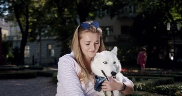 Ritratto bella giovane donna che tiene un cane husky tra le braccia e sorride . — Video Stock