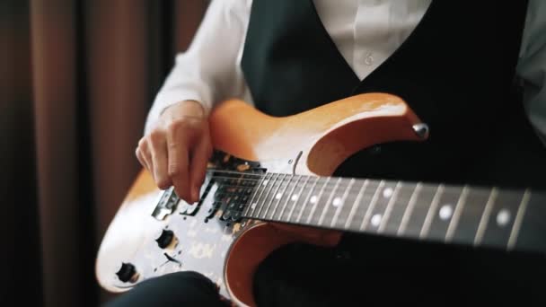 Uomo in giacca e cravatta che suona la chitarra. Primo piano dell'uomo mano che suona la chitarra — Video Stock