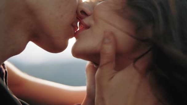 Vista de cerca extrema de una pareja joven bellamente apasionadamente besándose al atardecer, en cámara lenta. Historia de amor — Vídeos de Stock