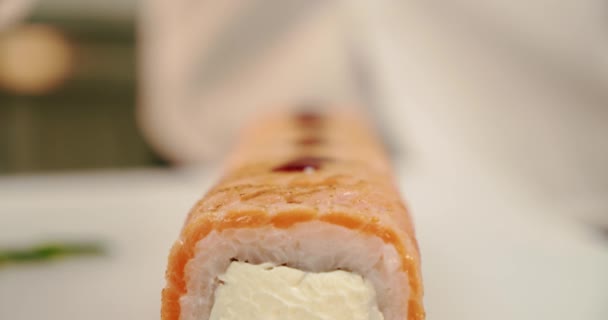 Sushi mästare färska sushi rullar dekorerar med sås nära utsikt — Stockvideo