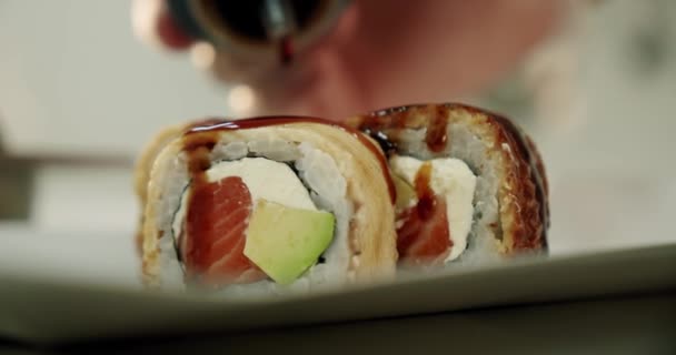 Zeitlupe. Sushi Master frische Sushi-Rollen mit Sauce dekoriert. Nahaufnahme — Stockvideo