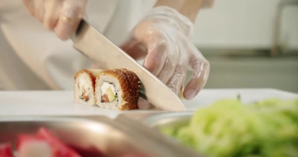 Zwolnij trochę. sushi mistrz świeże sushi bułki tnie rolkę z nożem. — Wideo stockowe