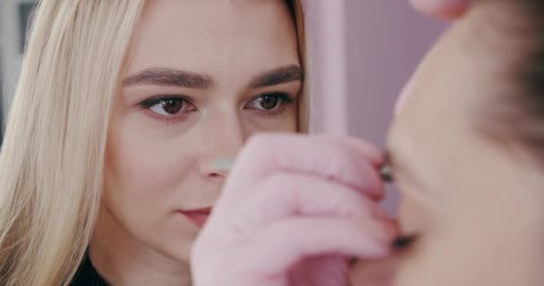 Wenkbrauwcorrectie vóór de procedure voor het tatoeëren. Maak permanente wenkbrauwen make-up. Langzame beweging. Sluiten. — Stockvideo