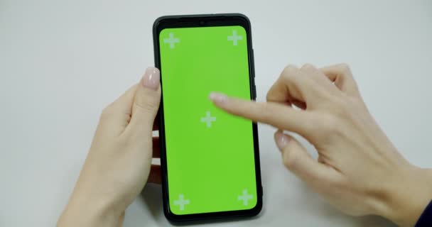 Womans hand holding a mobile telephone with a vertical green screen in tram chroma key smartphone technology cell phone street touch message display hand. Mock-up for Tracking or Watching Content Pov — Stock Video