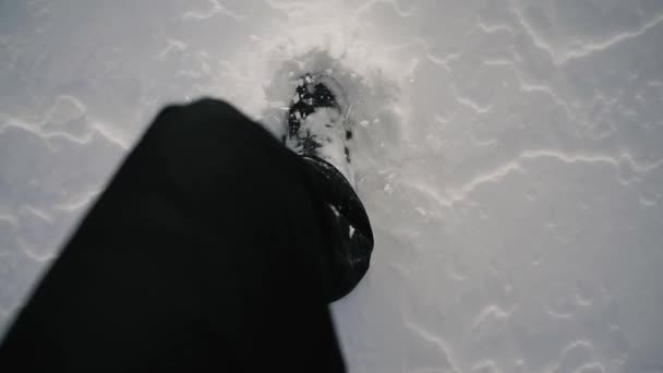 POV view on male feet in boots walking on snowy trail. Unrecognizable hiker strolling through forest. Close up Top View. Slow motion — Wideo stockowe