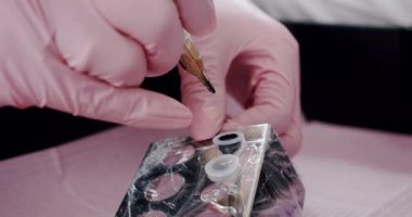 Dövme ustası dövme makinesine boya yazıyor. Kapat.