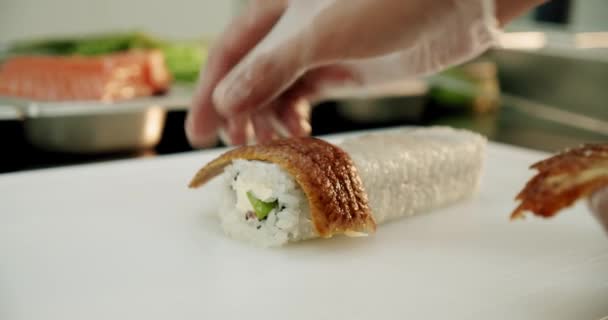 En cámara lenta. sushi master rollos de sushi fresco pone acné en el sushi. de cerca — Vídeos de Stock