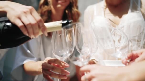 Крупним планом шампанське з білого вина вливають у келихи для вина. Повільний рух — стокове відео