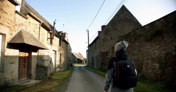 Incroyable prise de vue cinématographique, Jeune femme marchant dans de belles rues avec des maisons en pierre dans le village. Vue large, caméra coulissante — Video