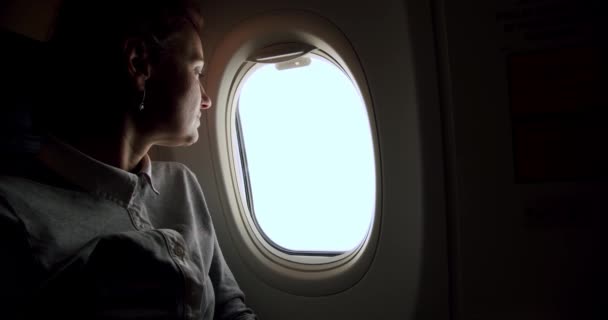 Incrível close-up de jovem mulher relaxada fecha o obturador da janela no avião voo ensolarado assento da janela. Movimento lento — Vídeo de Stock