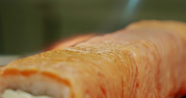 Extrem slow motion Restaurangkök. Manlig sushikock förbereder japanska sushirullar av ris, lax, avokado och nori. sushi framställs med hjälp av en brännare från Flame gun fackla. Närbild. — Stockvideo