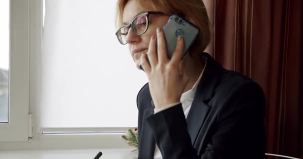 İş kadını ya da muhasebeci telefonda konuşuyor. Çağrıyı sonlandırır ve ofiste belgeyi imzalar, iş konseptini kapatır — Stok video
