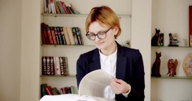 Siyah takım elbiseli başarılı bir girişimci kadın portresi ve elinde elinde bir kitap tutan gözlükler. Kameraya bakıyorum. Ver 2