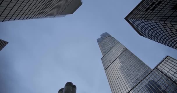 Titta upp på kvällen skyskrapor affärsbyggnader i dowmtown, moln rullar på himlen och reflektioner om glas — Stockvideo