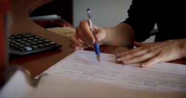 İş kadını ya da muhasebeci elinde kalemle doküman işi verileri tutuyor, verileri doğruluyor ve ofisteki muhasebe belgesinde bir damga ile imzalıyor, iş konseptini kapatın. Kaydırma kamerası