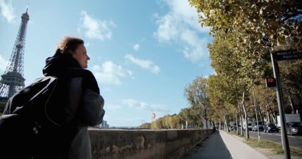 Touristinnen mit Rucksack spazieren durch die Stadt Paris, vorbei am Eiffelturm und der Seine, und machen Fotos mit dem Smartphone. Weitschuss — Stockvideo